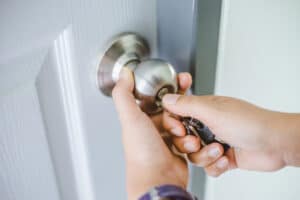 Woman's hand unlocking the door with a key